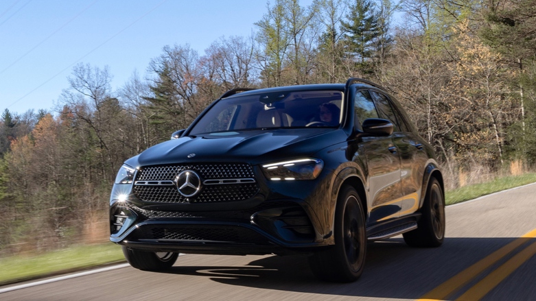 Vista frontal de auto de lujo Mercedes-Benz GLC Coupé 200 negro conduciendo sobre autopista cerca a la bahia.