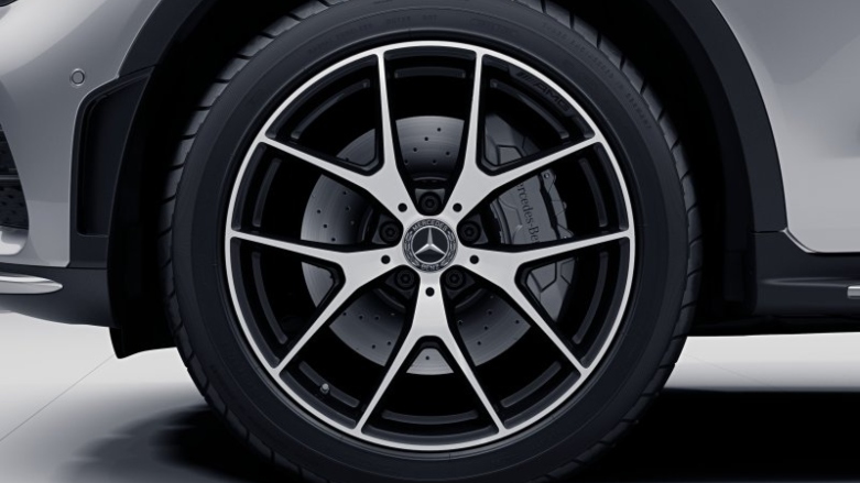 Vista cercana de neumatico delantero con rin de lujo de camioneta 4x4 Mercedes-Benz GLC 4Matic color gris.