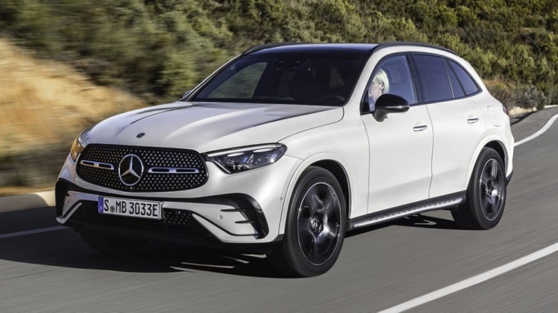 Vista frontal de SUV Mercedes-Benz GLC color blanca siendo conducida por mujer en carretera.