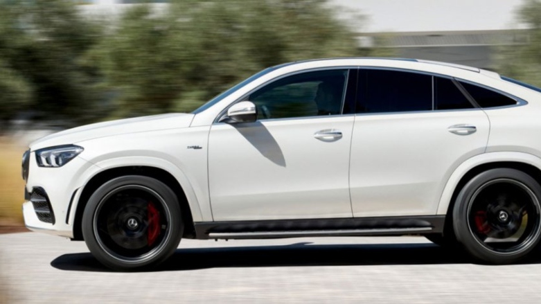 Vista lateral de Mercedes-AMG GLE color blanco siendo conducido por autopista.
