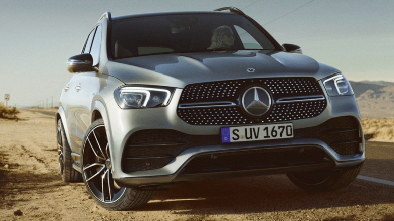 SUV híbrido Mercedes-Benz GLE 450 color gris en terreno arenoso al costado de la carretera.